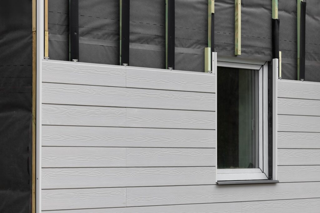 wood texture composite cladding installation on house facade. WPC exterior wall panels