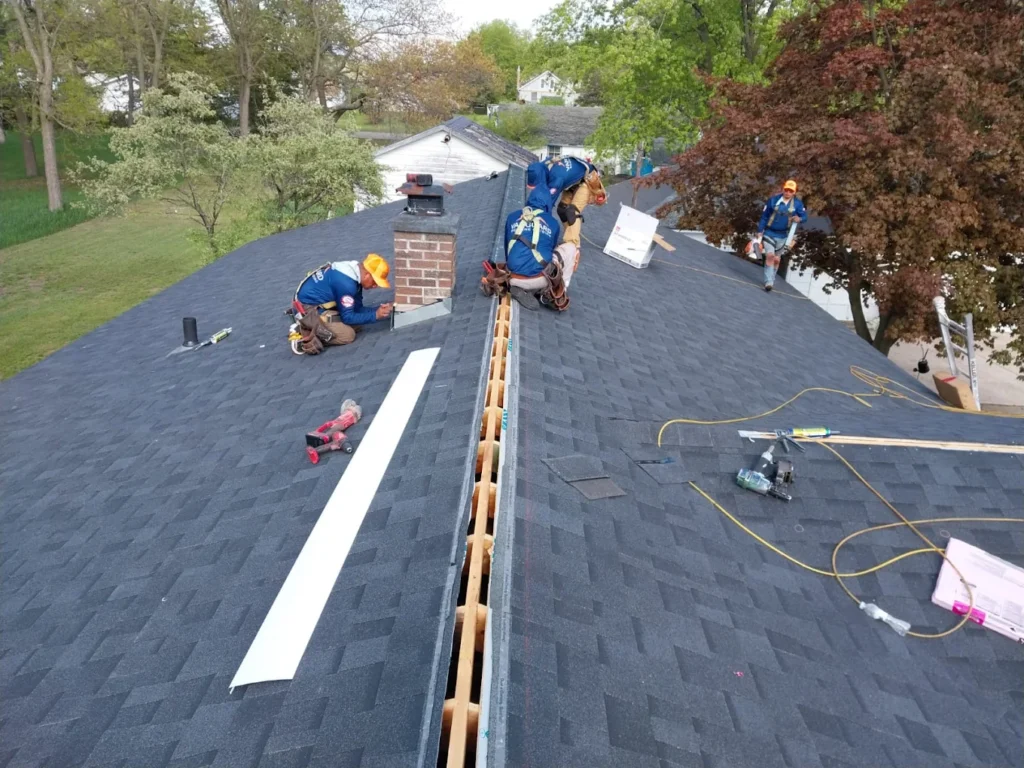 Vanguard team installing dark grey shingles on a roof