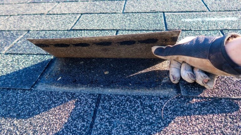 roofing inspection report hand lifting one shingle unglued