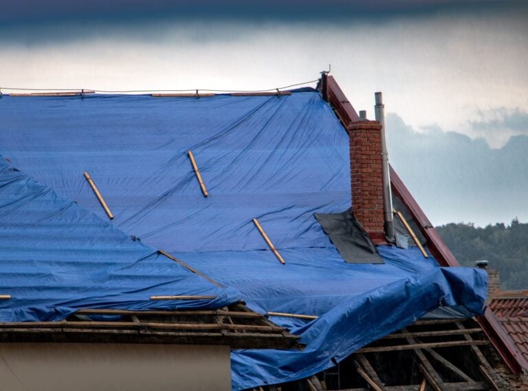The tarp covers the roof of the old house