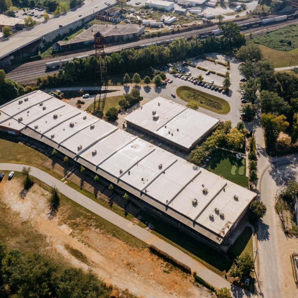 Aerial view of large commercial flat-roof buildings for a roofing company near me
