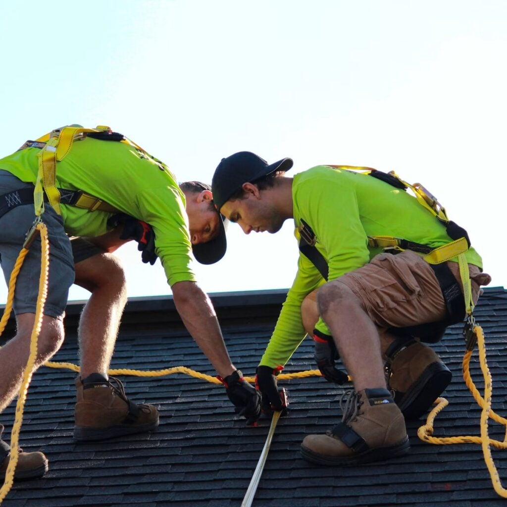 Roofing professionals installing shingles on a home for a dependable roofing company in Will County, IL