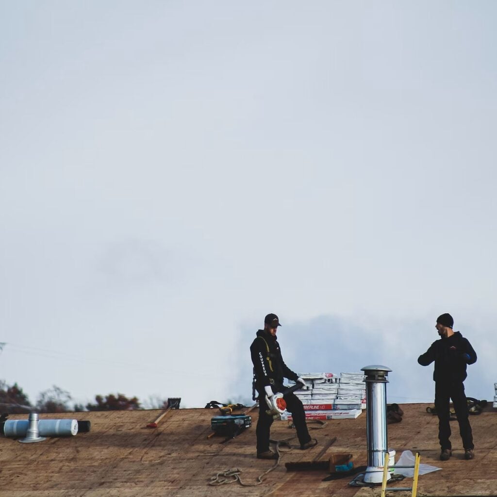 Roofing professionals working on a roof for a roofing company near me