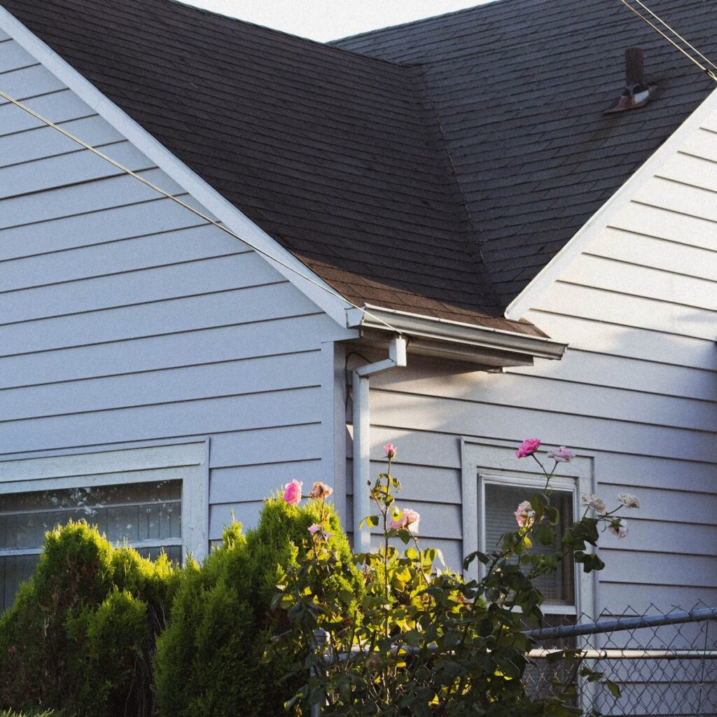 Residential shingle roof with gutters and siding for a roofing company near me