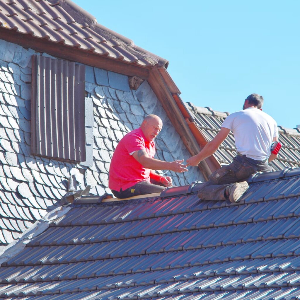 Roofing professionals working on a tile roof for a quality-focused roofing company in Plainfield, IL
