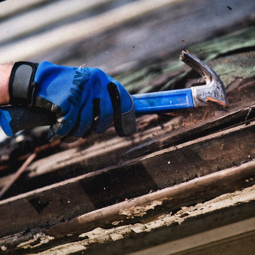 Close-up of a roofing professional using a hammer for a roofing company near me