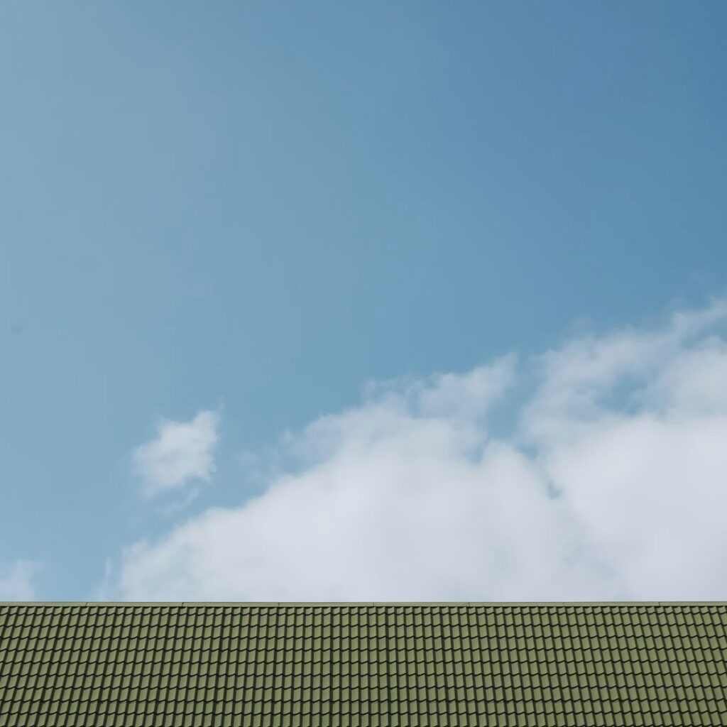 Green tile roof beneath a blue sky for an experienced roofing company in Frankfort, IL